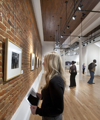 A student looks at work in an exhibition at the Paul R. Jones Museum.