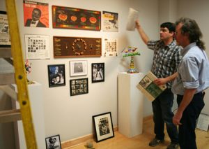Curator Lee Shook and Johnny Williams, Raudelunas member and founder of Alabama Art Casting, hang art work in the Ferguson Gallery.
