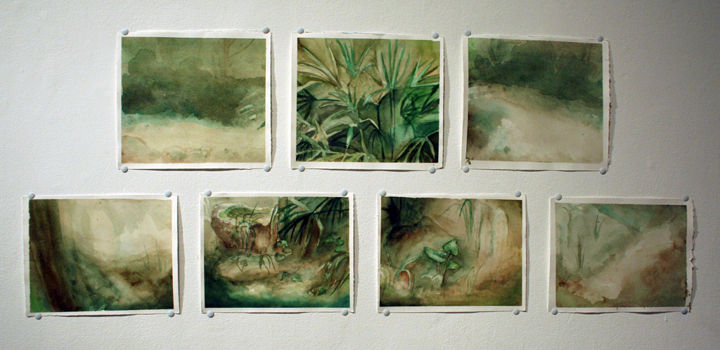 a collection of paintings hanging on a wall