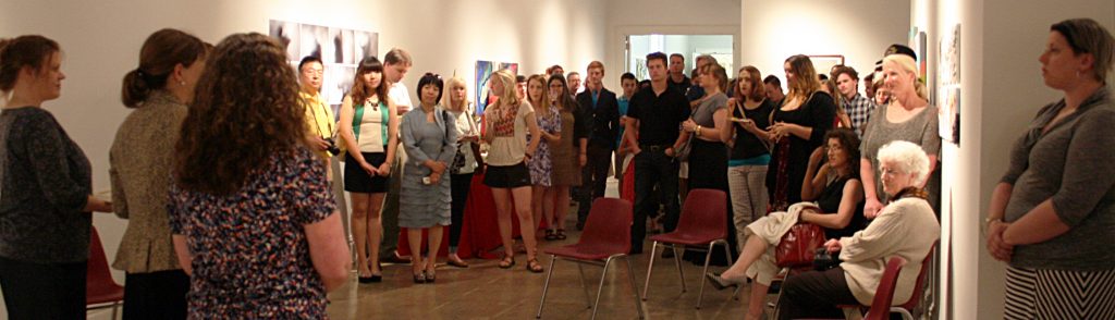 students, parents, and faculty gathered in a gallery