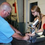 Craig Wedderspoon helps Alli Sloan put finishing touches on her steel sculpture for Nucor Children's of Alabama charity auction.
