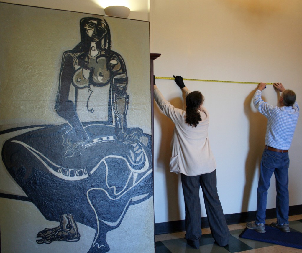 Emily Bibb and Bill Dooley measure the space for "Cassandra" by Ben Smith in the foyer of Morgan Hall.