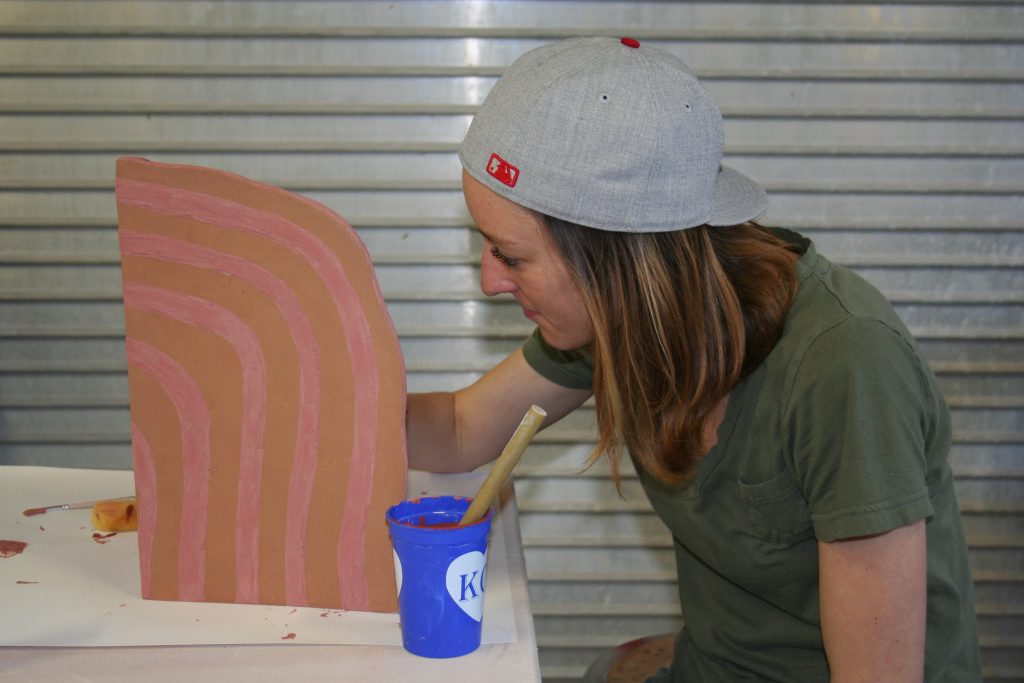 Grad student Sydney Ewerth paints a ceramic piece that will be part of a sculptural installation by artist Amy Pleasant.