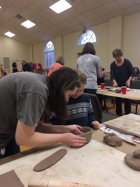 Crimson Clay president and grad student in ceramics Amy Smoot teaches an attendee how to make ceramic bowls ahead of the 2018 Empty Bowls project at Grace Presbyterian Church in Tuscaloosa, before the event.