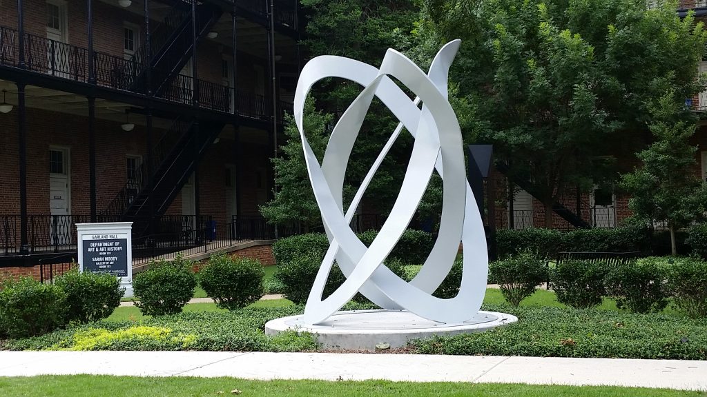 a tall sculpture that looks like linked, twisted loops of white paper
