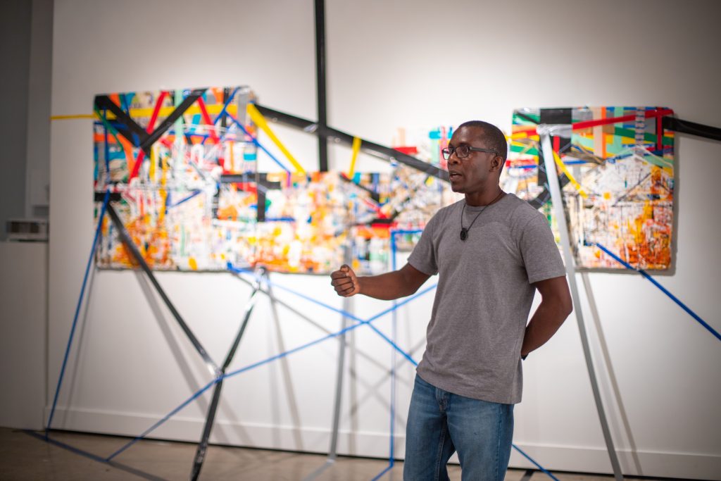 Jude Anogwih talks about his work in the Graduate Student Exhibition 2018. Photo by Alyssa Gutierrez, courtesy College of Arts and Sciences.