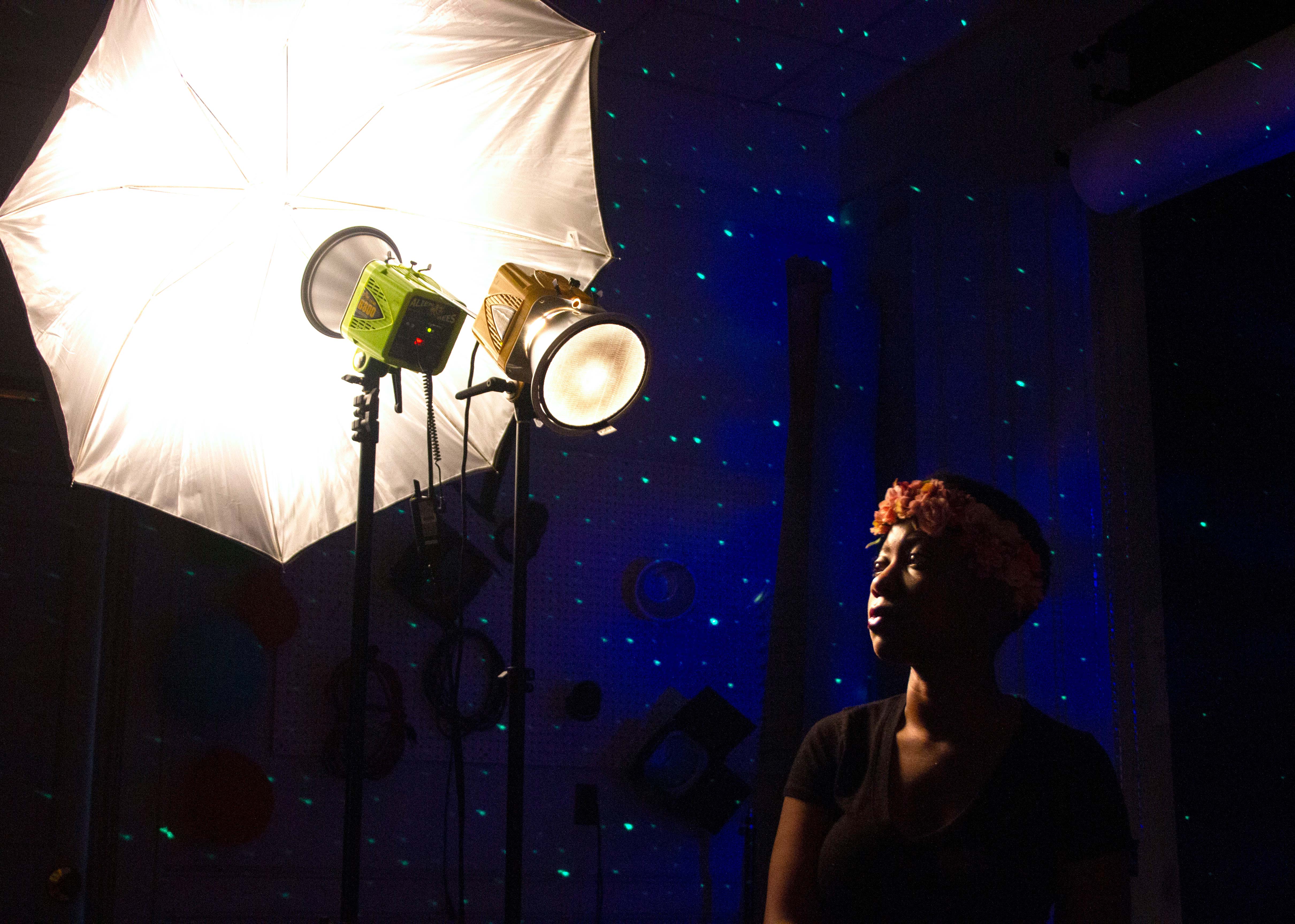 a woman standing under studio lighting
