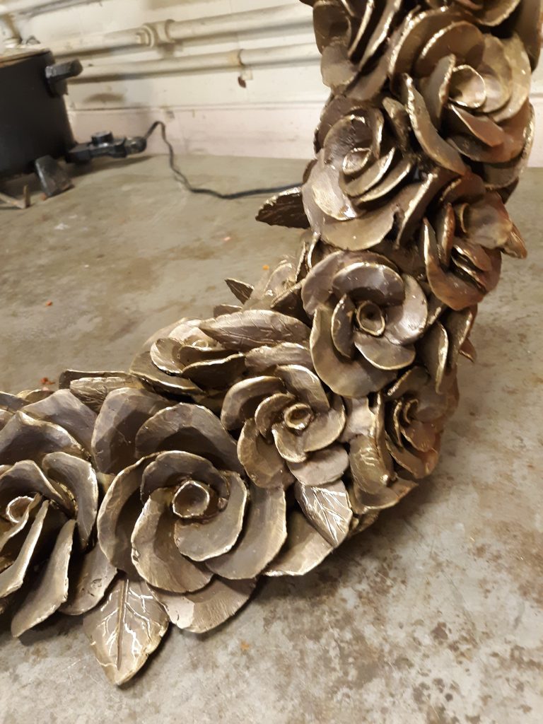 Close-up detail of a half circle of cast bronze camellias.