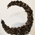 A half circle of cast bronze camellias.