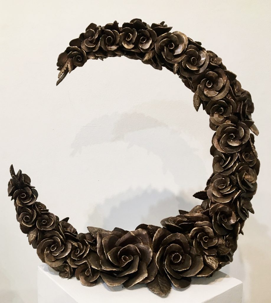 A half circle of cast bronze camellias.