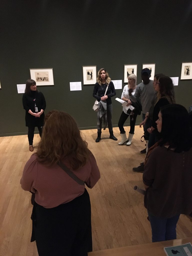 Students stand in a circle with museum curator.