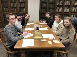 students sit around a table in a library