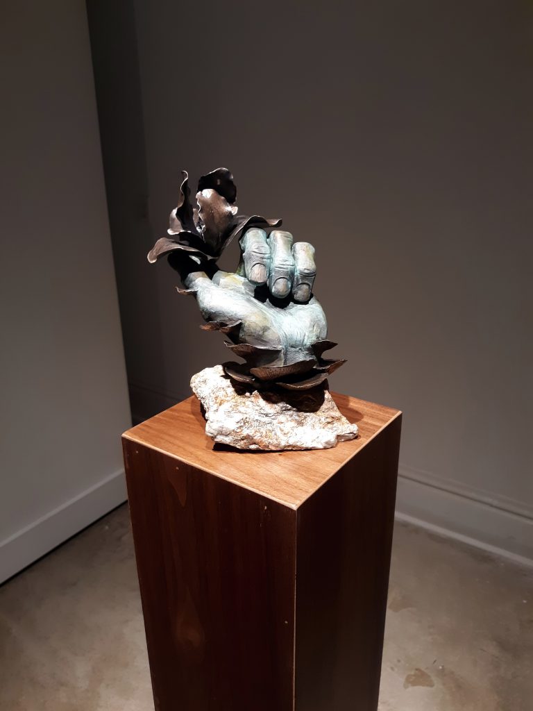bronze hand holding flower