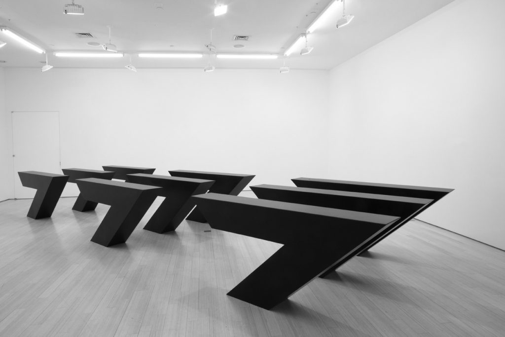 large black Minimalist sculpture, installed indoors