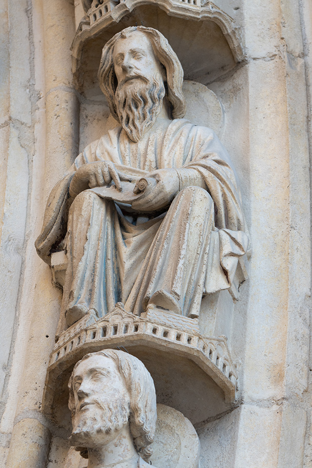 Stone sculpture of a Biblical prophet on an exterior cathedral wall.